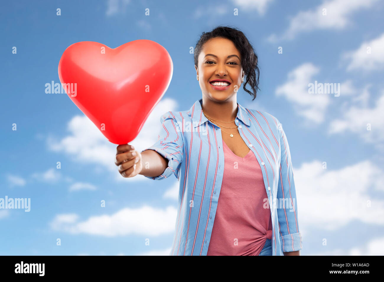 African American Woman with heart-shaped balloon Banque D'Images