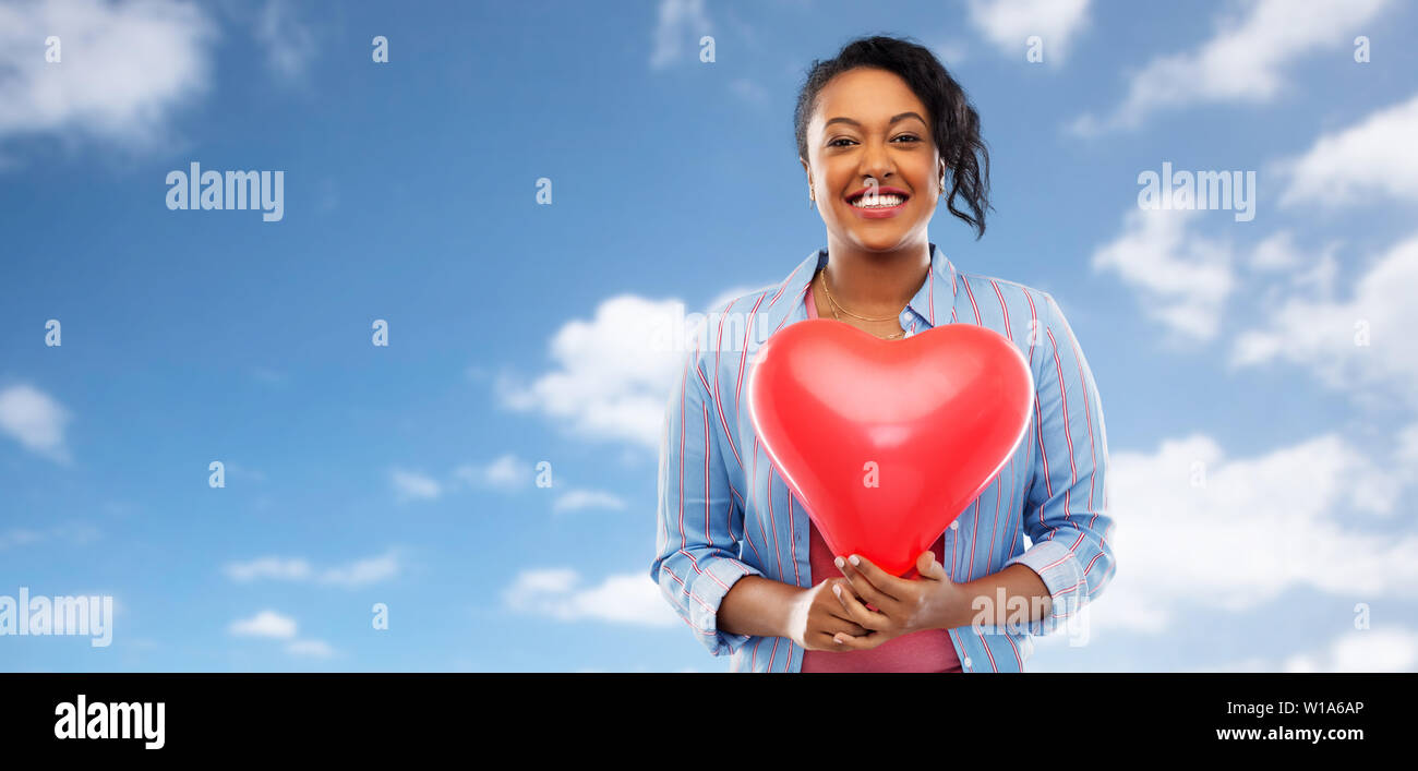 African American Woman with heart-shaped balloon Banque D'Images