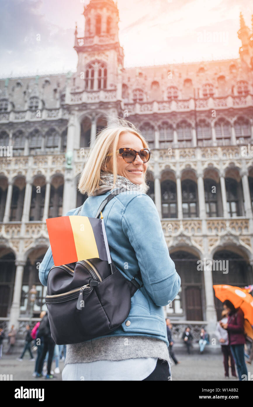 Woman traveler avec sac à dos et pavillon de la Belgique se tient sur la  Grand Place à Bruxelles, Belgique Photo Stock - Alamy