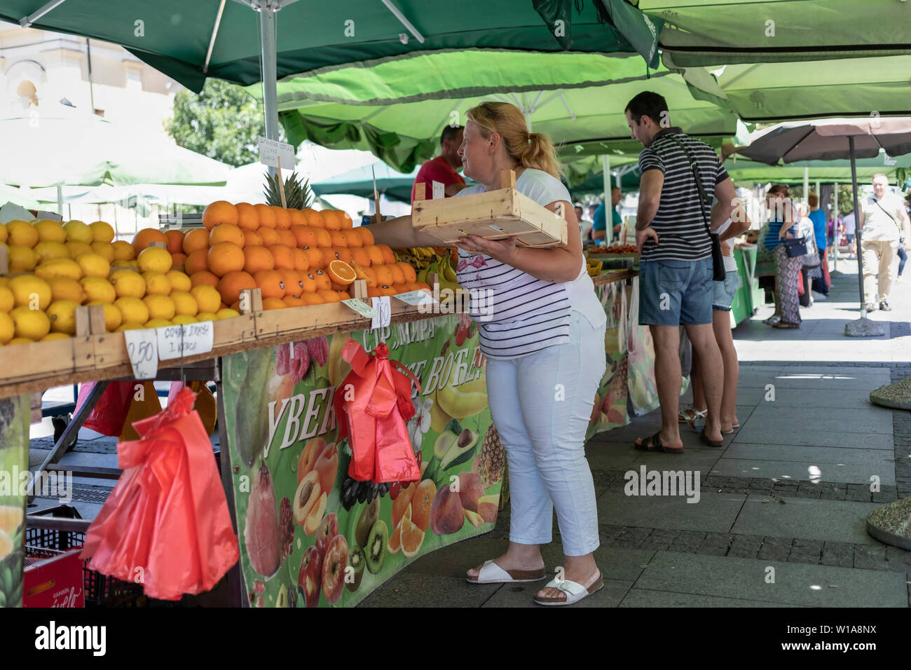 Belgrade, Serbie, 28 juin 2019 : le tri des oranges sur son étal de fruits au marché vert Zemun Banque D'Images