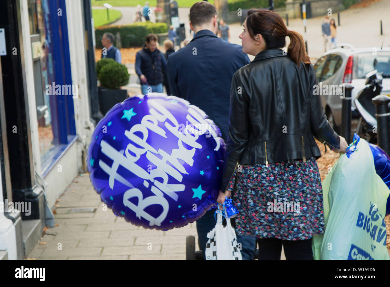 Femme Faisant Du Shopping Dans Un Centre Ville Et Tenant Un Ballon Bleu Joyeux Anniversaire Avec Des Lettres Blanches Harrogate North Yorkshire Angleterre Royaume Uni Photo Stock Alamy