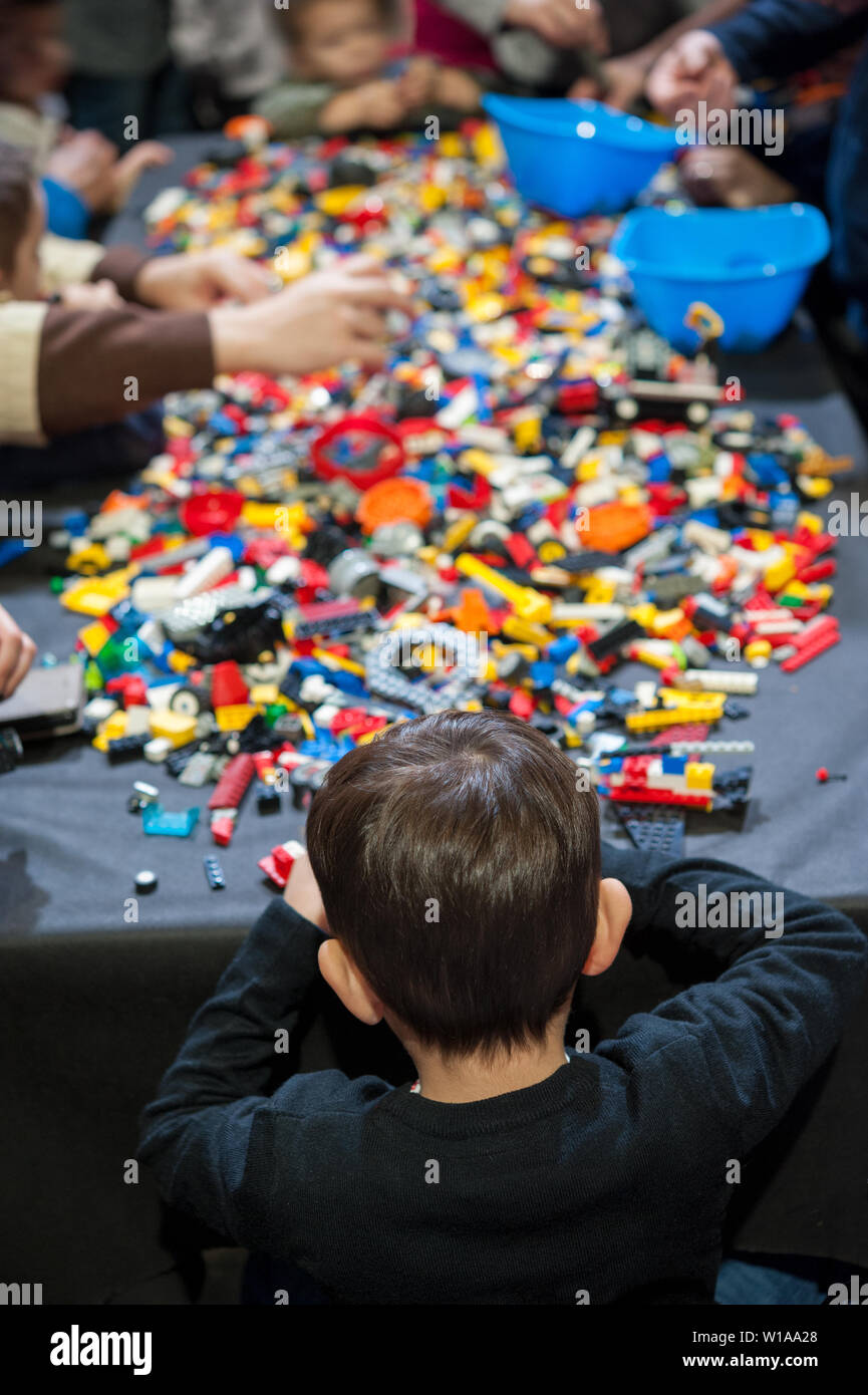 Enfants jouant avec des milliers des briques Lego sur la table. Banque D'Images
