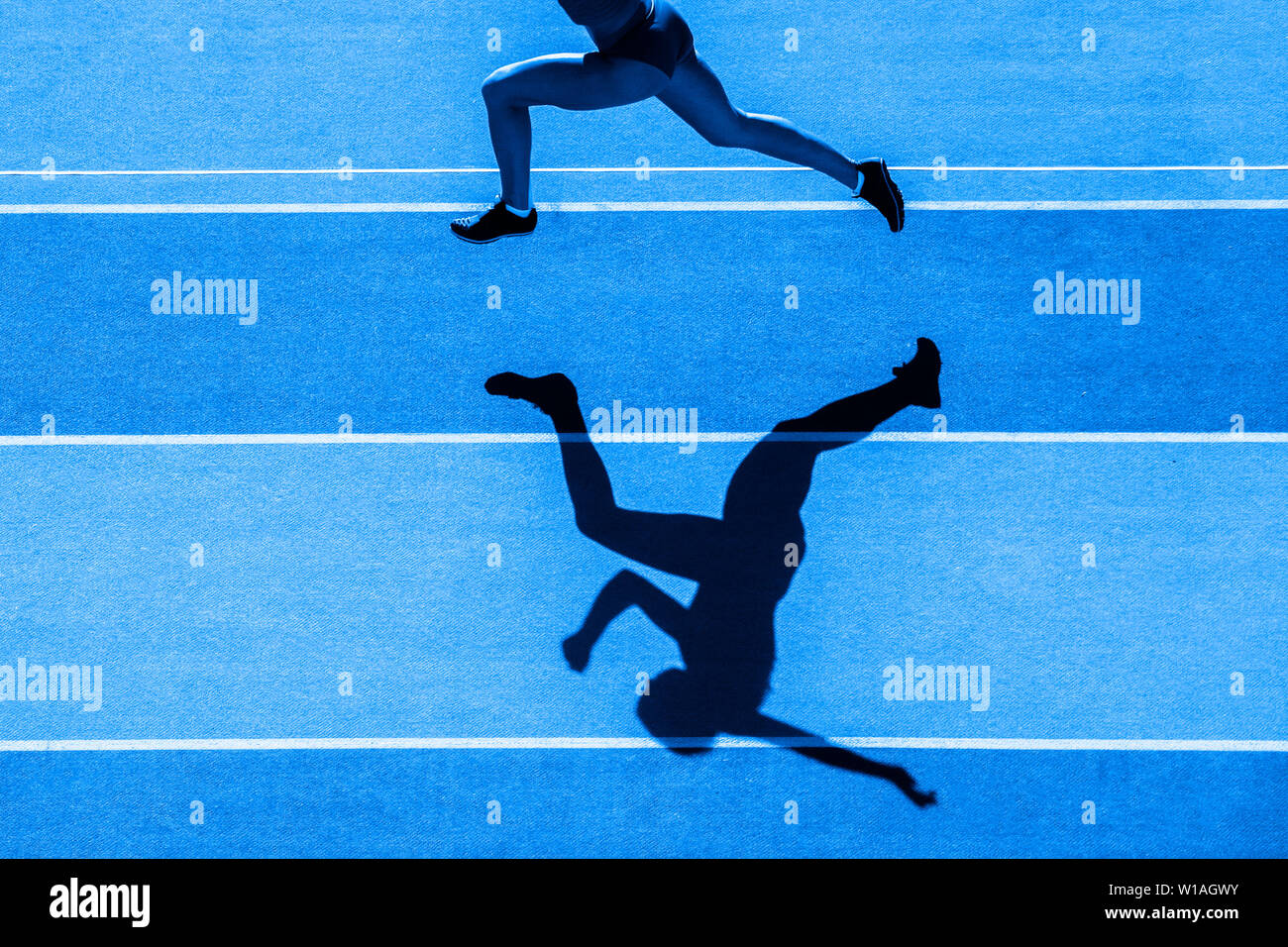 Un caucasian woman runner jogger running en silhouette sur l'arrière-plan du stade. Filtre de couleur bleu. Banque D'Images