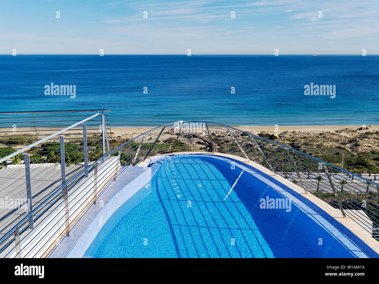 Voir une partie de bord de piscine et vue de la plage de sable sur la mer Méditerranée. Province d'Alicante, Costa Blanca, Espagne Banque D'Images