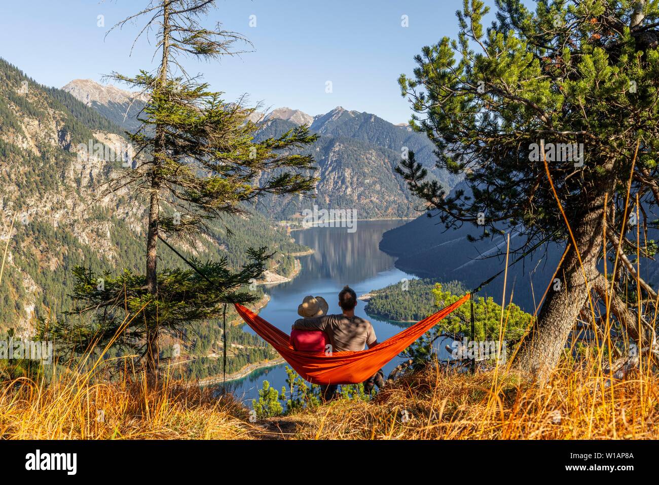Paire assis dans un hamac avec vue panoramique sur les montagnes et le lac,  le lac Plansee, Alpes Ammergau, district de Reutte, Tyrol, Autriche Photo  Stock - Alamy