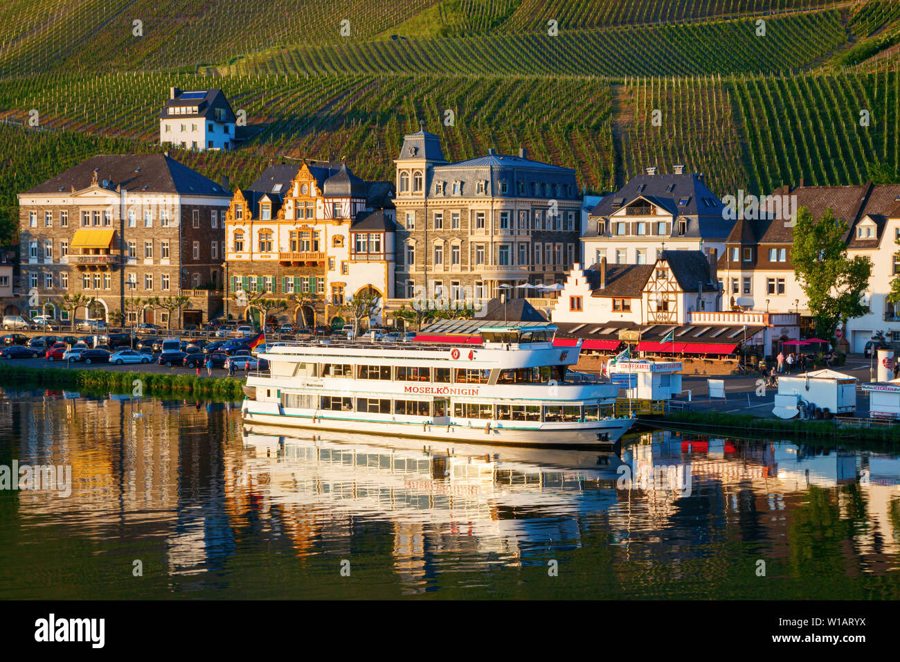 Vue sur la Moselle avec bateau de tourisme, la rue Gestade et vignobles au coucher du soleil. Bernkastel-Kues, Rhénanie-Palatinat, Allemagne. Banque D'Images
