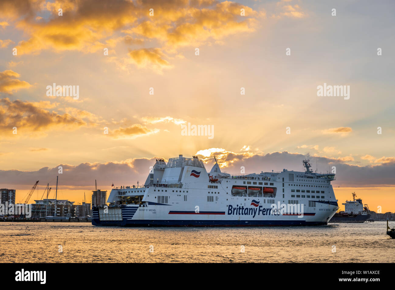 Personnes à bord profitez de la vue que le 'Mont St Michel', détenu et géré par Brittany Ferries, entre dans le port de Portsmouth au coucher du soleil sur la rivière Banque D'Images