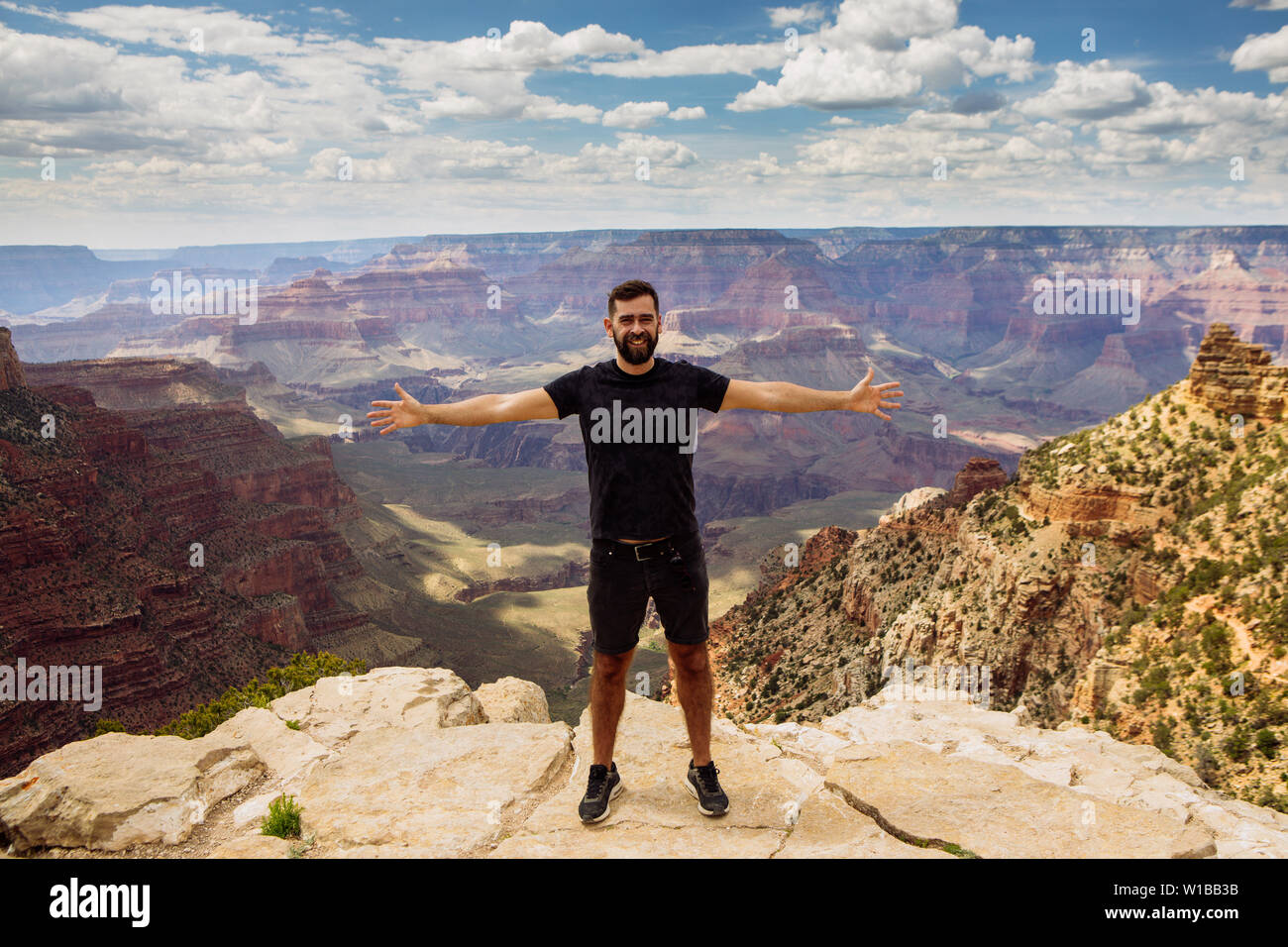 L'homme de l'avant près d'une falaise dans la région de South Rim avec bras ouverts au Grand Canyon National Park, Arizona, USA Banque D'Images