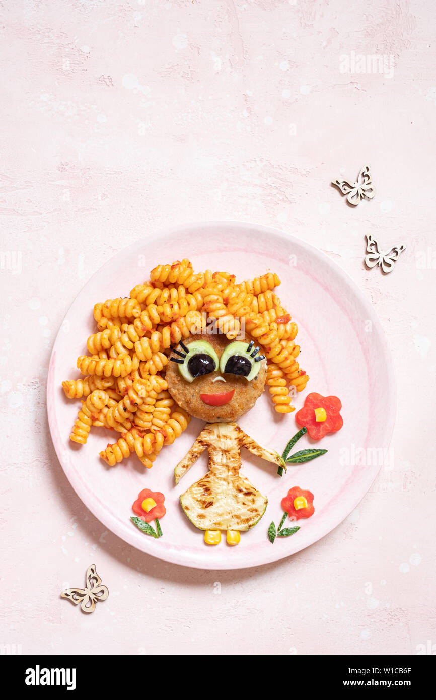 Funny Girl face à la nourriture avec escalope, pâtes et légumes Banque D'Images