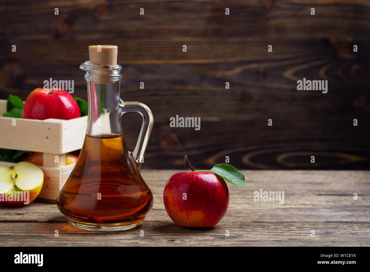 Le vinaigre de cidre de pomme rouge et fraîche sur un fond de bois Banque D'Images