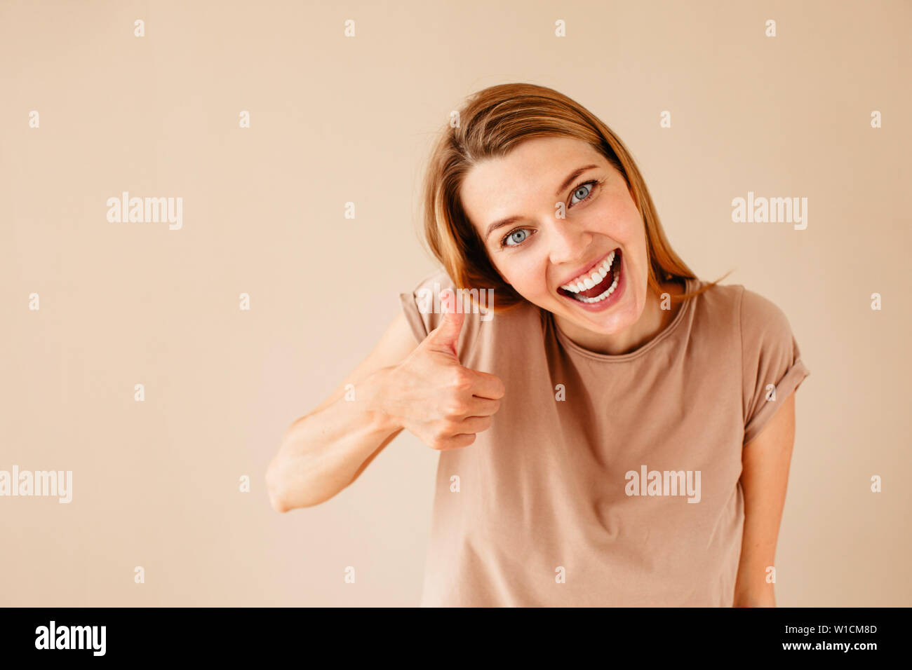 Excited woman gesturing thumb up Banque D'Images