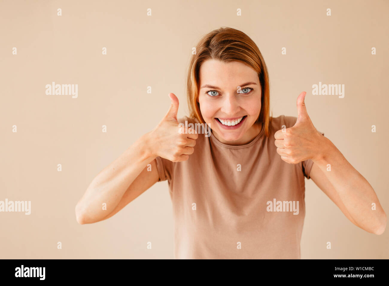 Excited woman gesturing thumb up Banque D'Images