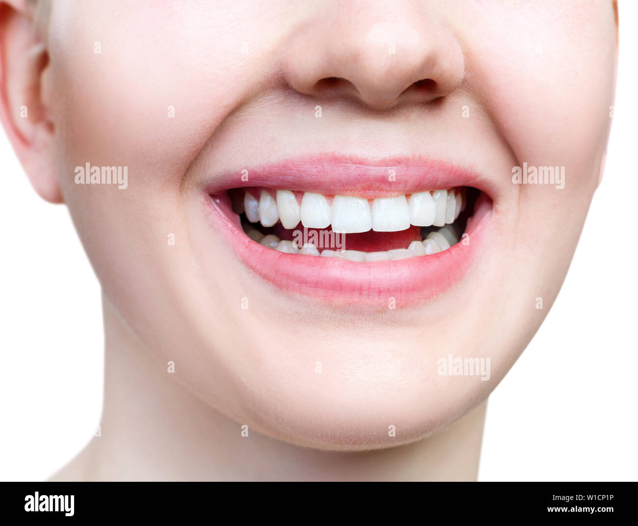 Close-up sourire en santé de jeune femme. Les dents blanches parfaites. Isolé sur blanc. Banque D'Images