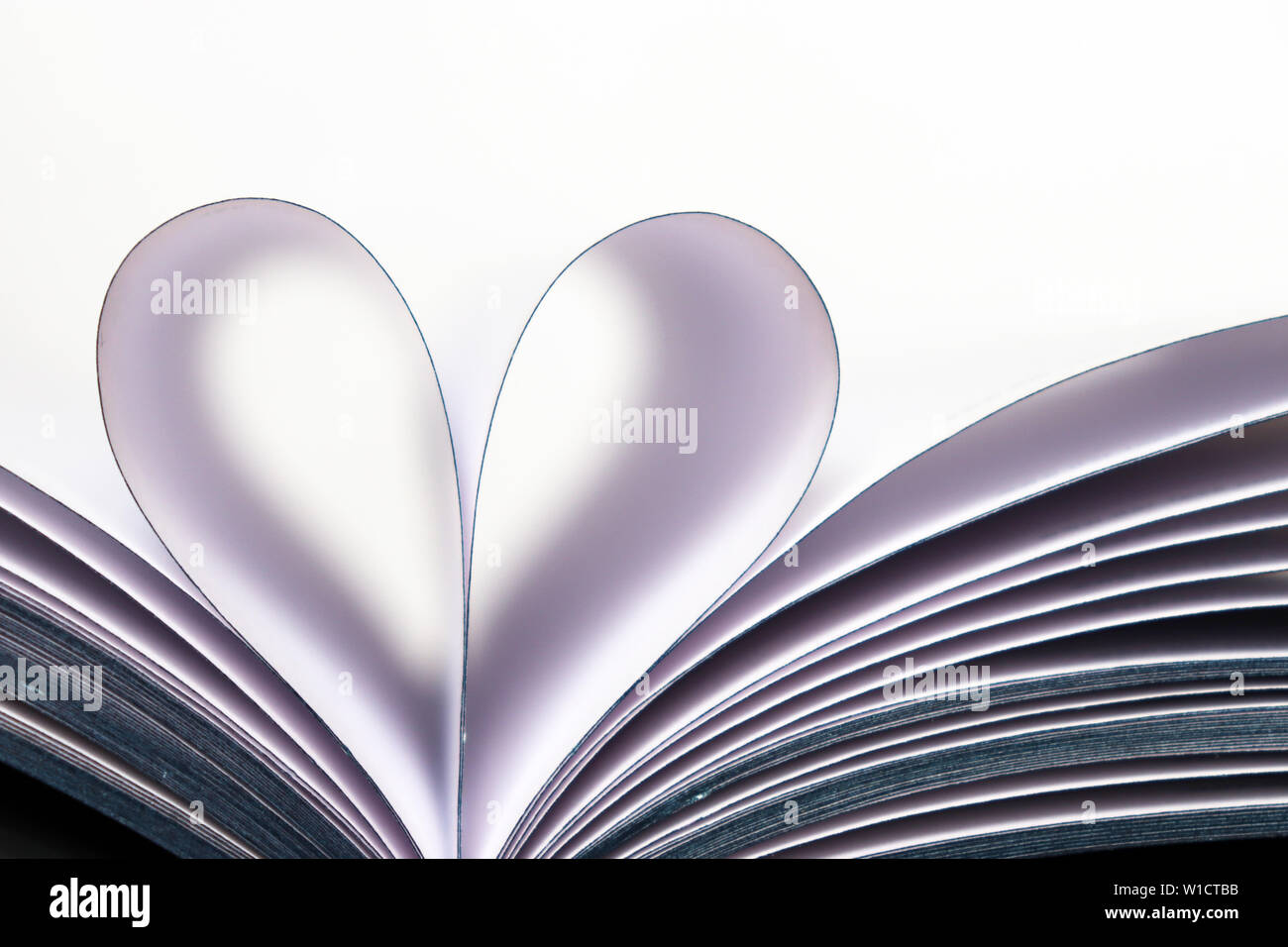 Des pages de livre ouvert en forme de coeur isolé sur fond blanc. Pour l'amour de la lecture, concept de la science, de l'apprentissage, romance Banque D'Images