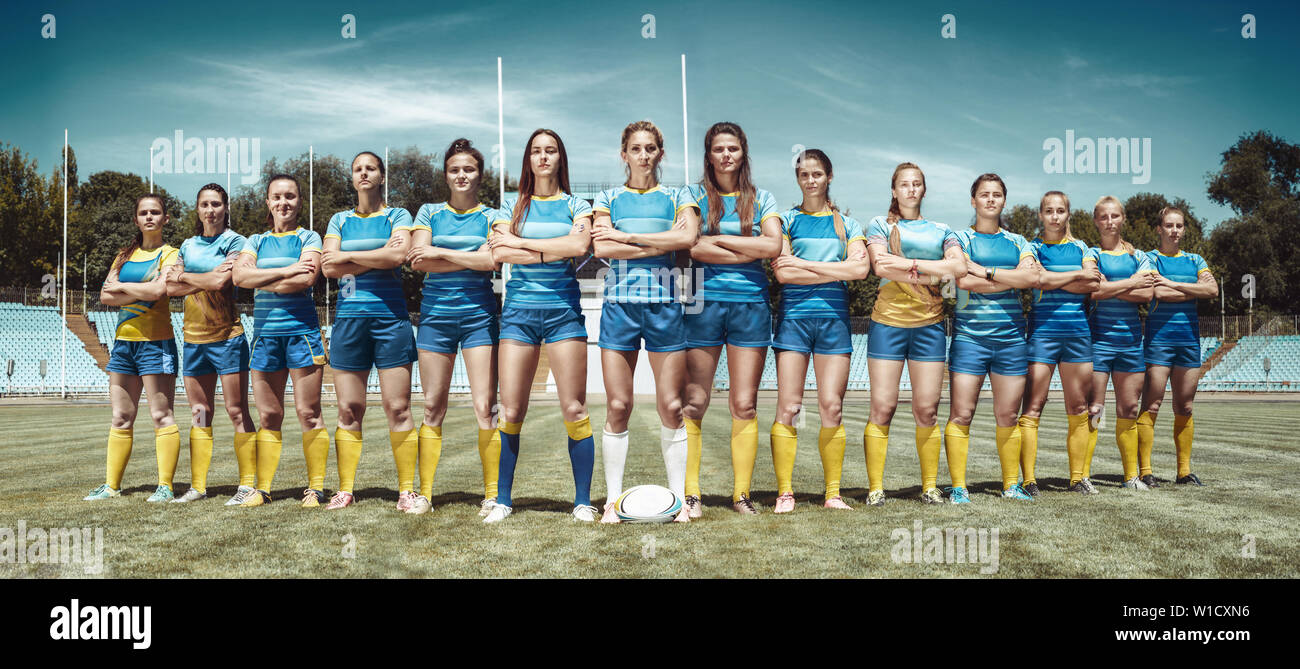 La force et la beauté. L'équipe féminine de rugby les joueurs de passage permanent part dans le stade en journée ensoleillée. Mettre en place des modèles de race blanche comme un professionnel de la sportive. Compétition sportive, motion, le mouvement, la lutte. Banque D'Images