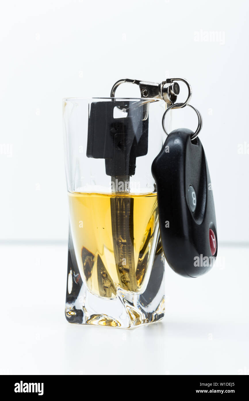 Clé de voiture sur le bar avec alcool renversé Banque D'Images