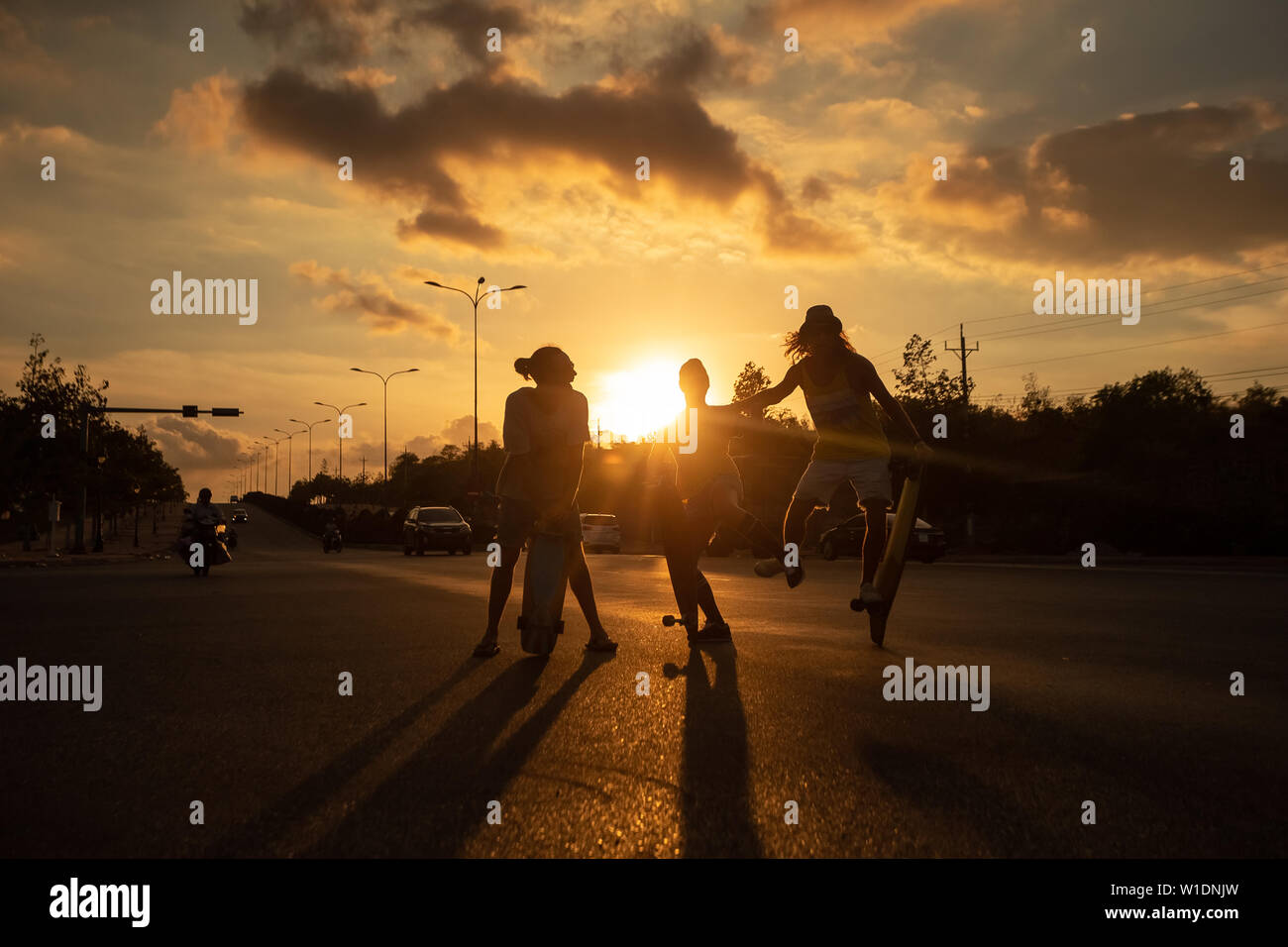 Un jeune skateboarder caucasienne rides skateboard au coucher du soleil Banque D'Images