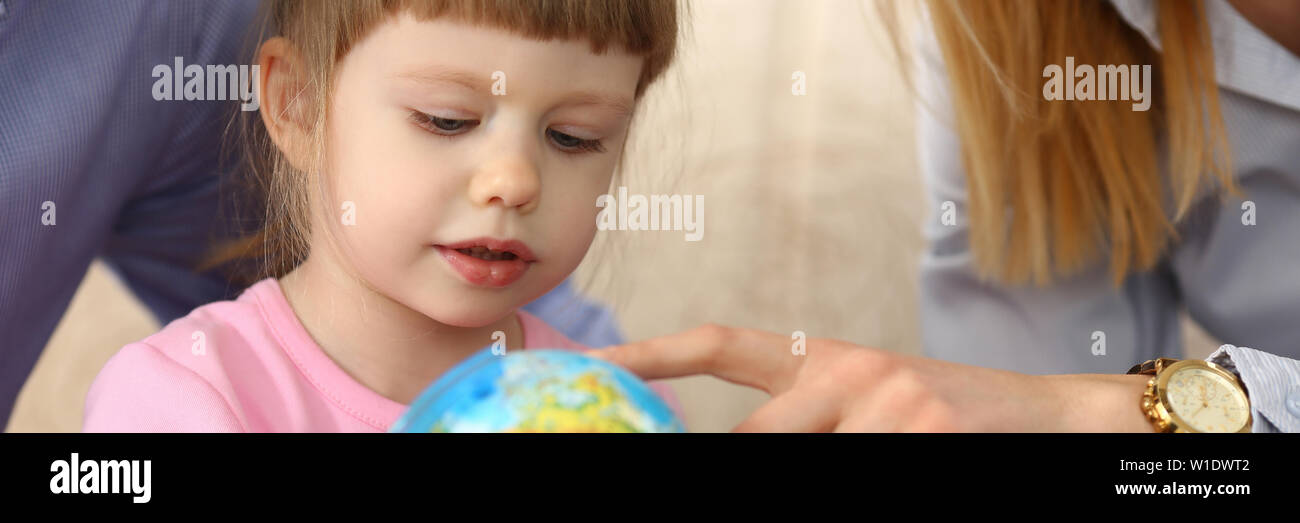 Petite fille l'apprentissage de la navigation et qui achemine holding globe in arms Banque D'Images