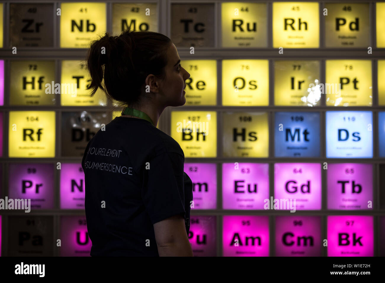 Exposition de la Société Royale des Sciences d'été, une jeune femme à la recherche à un tableau périodique en célébration du 150e anniversaire, London, UK Banque D'Images