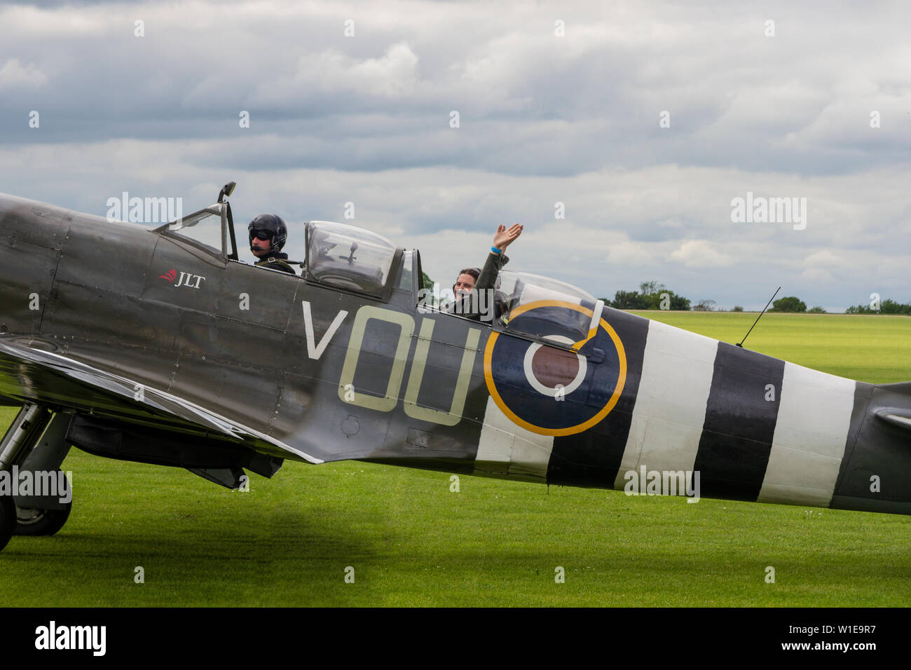Supermarine Spitfire WW2 vintage à deux places avec l'un des membres de l'équipage agitant alors qu'ils prennent un taxi pour décoller de l'aérodrome de Sizewell, en Angleterre Banque D'Images