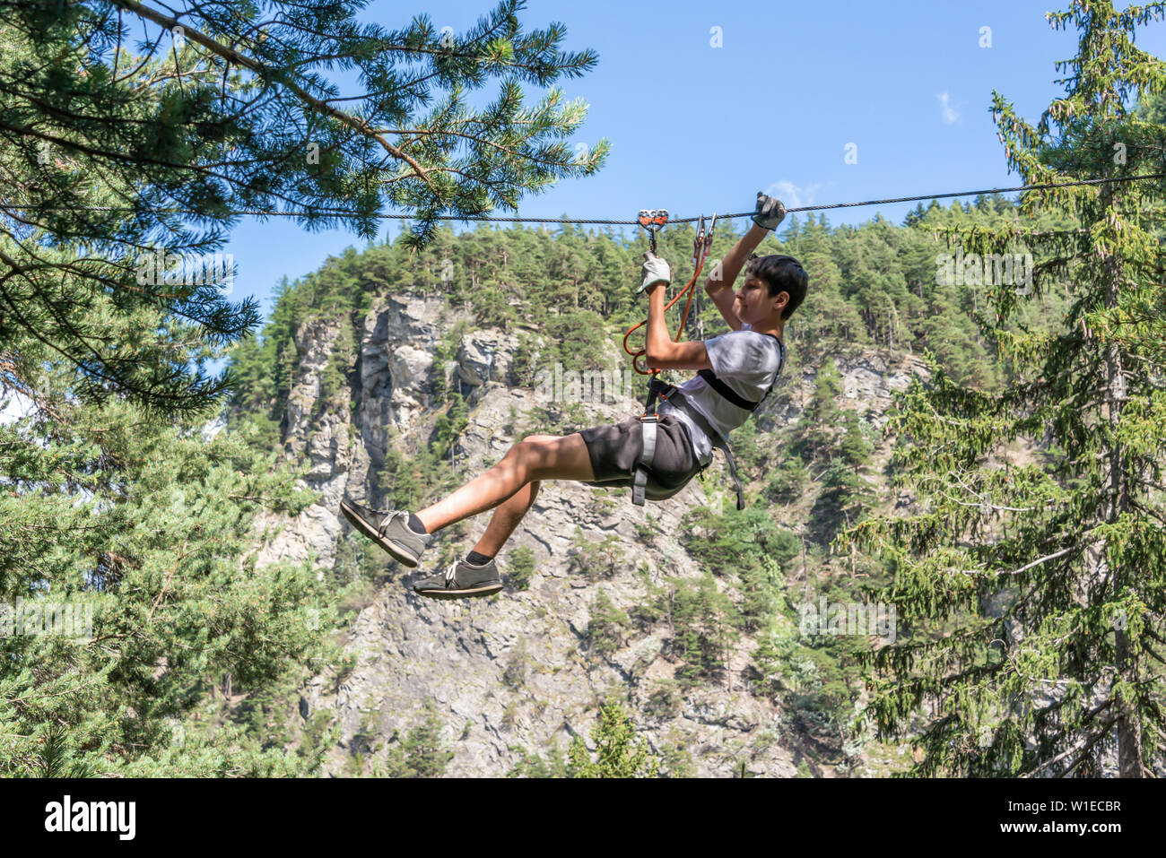 Adolescent tyrolienne sur des parcours, l'aventure, parc, grimper aux arbres dans une forêt en été Banque D'Images