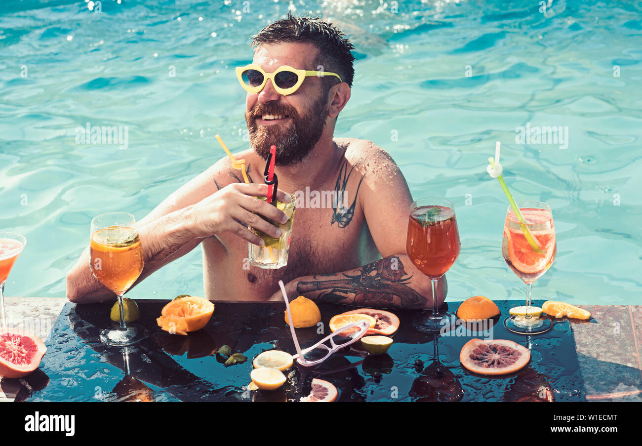 Chill out dans piscine d'été. chill out de l'homme barbu avec des cocktails et des fruits. Banque D'Images