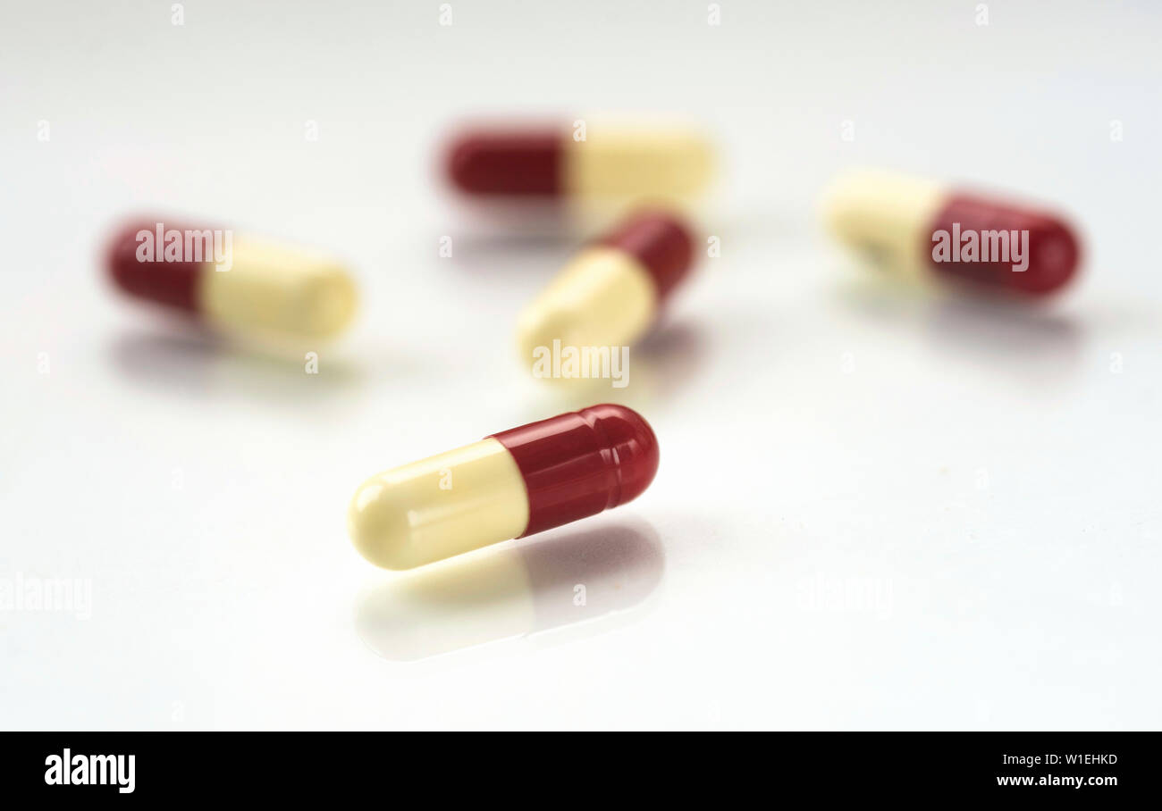 La pénicilline antibiotique capsules répandus sur un fond blanc réfléchissant. Banque D'Images