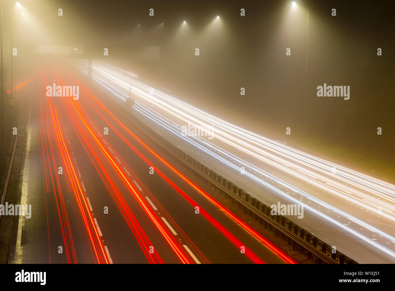 La circulation sur autoroute trail des lumières la nuit, M8, Ecosse, Royaume-Uni, Europe Banque D'Images