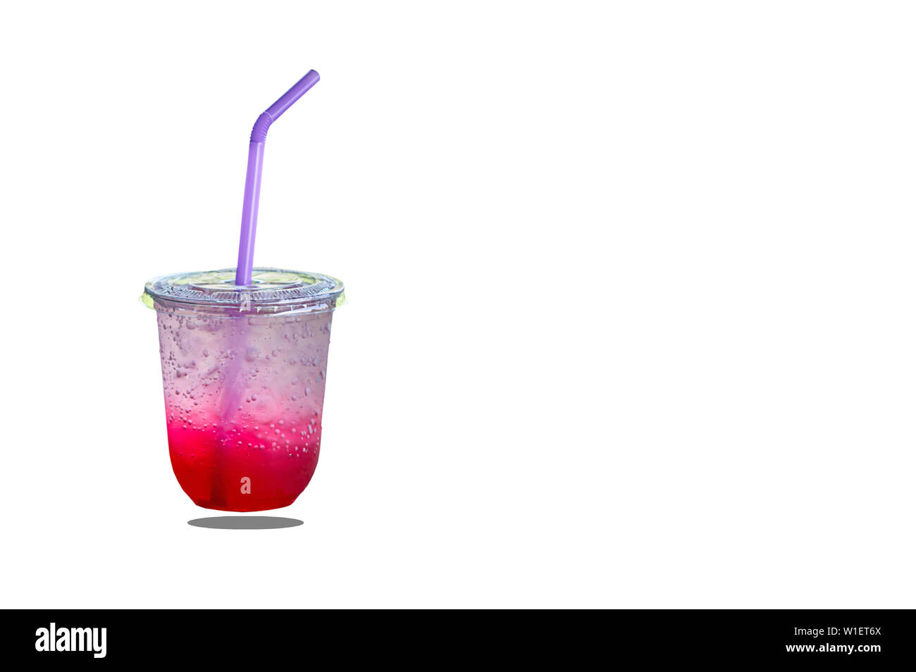 Jus rouge isolé avec de la glace dans un verre en plastique sur fond blanc. avec chemin de détourage. Banque D'Images