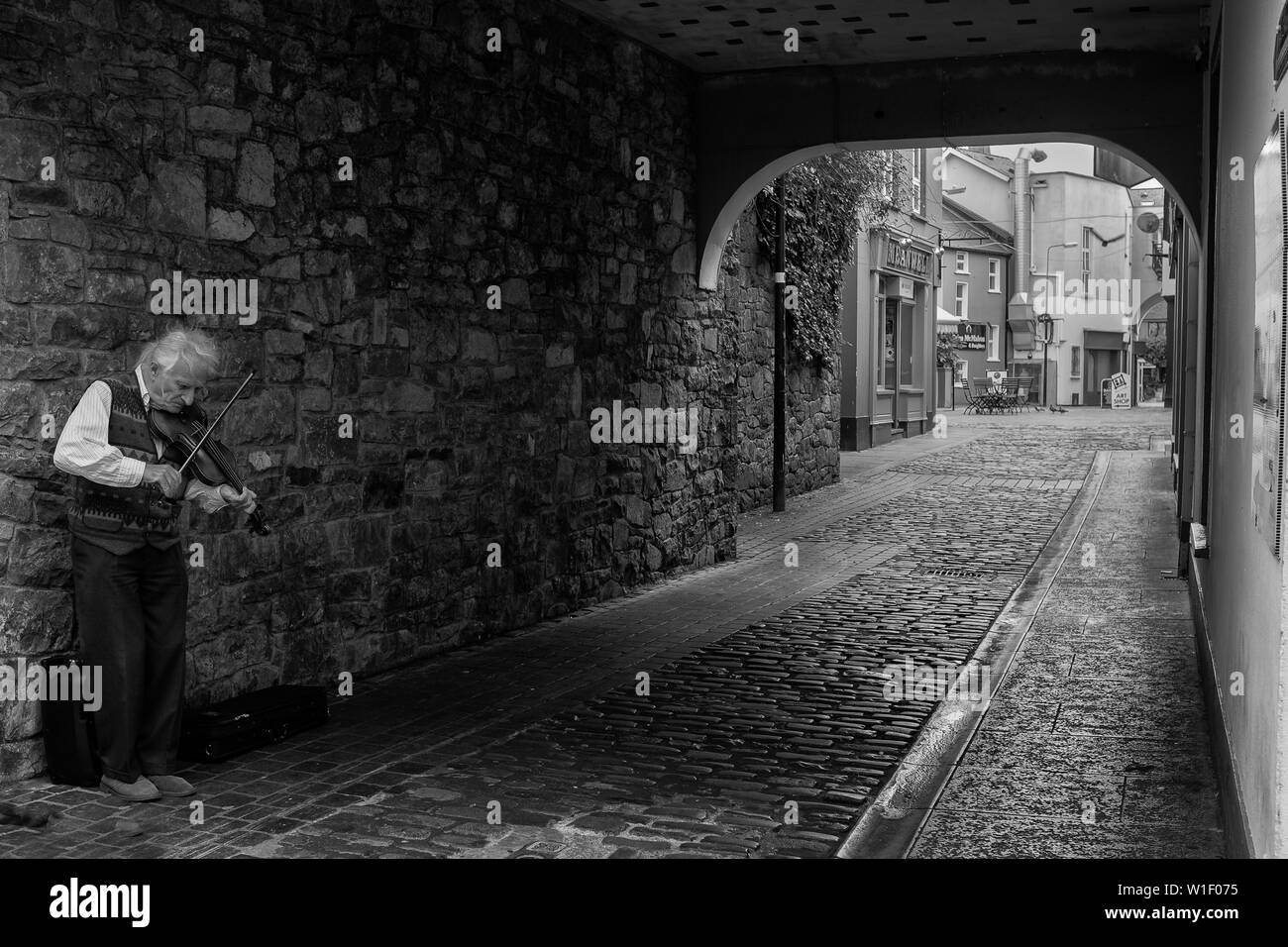 Ennis, dans le comté de Clare, Irlande, juin, 6, 2019 : Un vieux monsieur de la rue avec son violon dans les rues d'Ennis, dans le comté de Clare, Irlande en noir et Banque D'Images