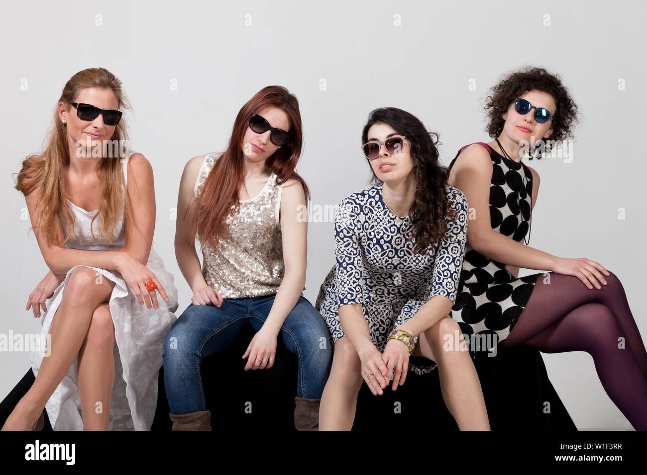 Quatre belles femmes posent ensemble en studio Banque D'Images