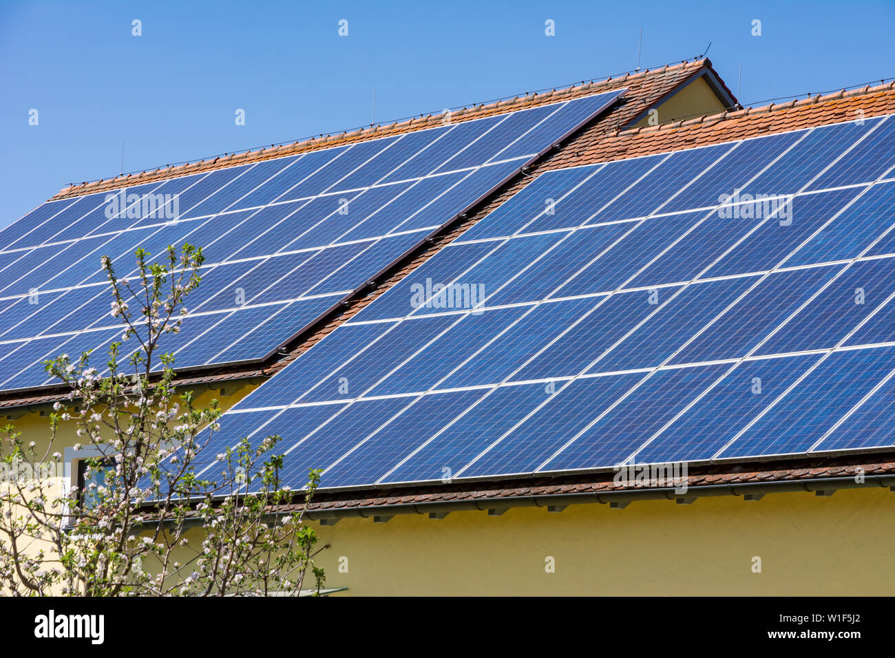 Maison moderne avec les cellules solaires photovoltaïques sur le toit pour la production d'énergie de remplacement Banque D'Images