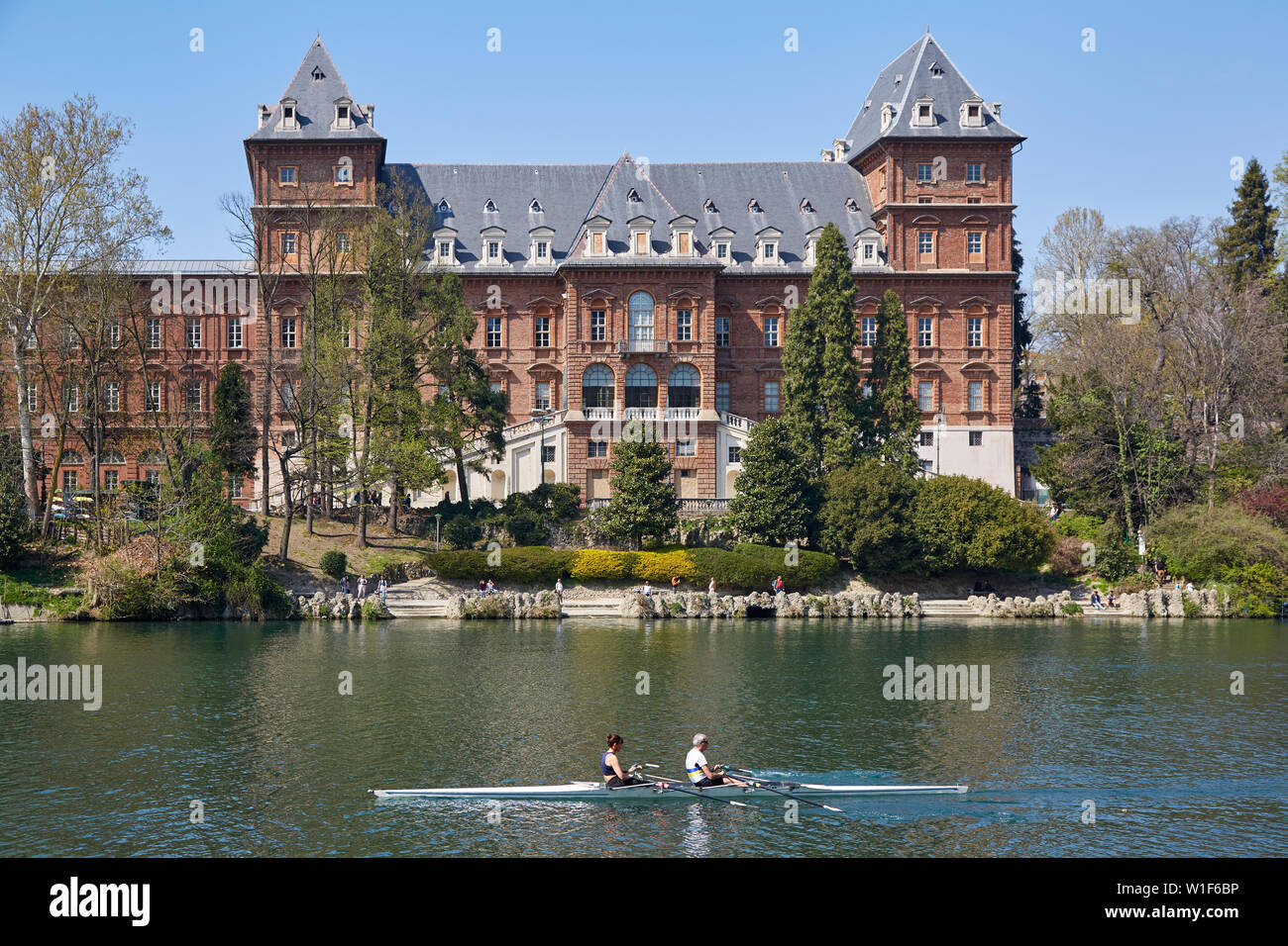 TURIN, ITALIE - 31 mars 2019 : Château du Valentino et fleuve Po avec les gens l'aviron dans une journée ensoleillée dans le Piémont, Turin, Italie. Banque D'Images