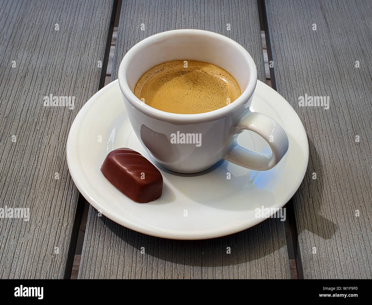 Tasse d'espresso avec petit chocolat praliné sur gris rustique table. Banque D'Images