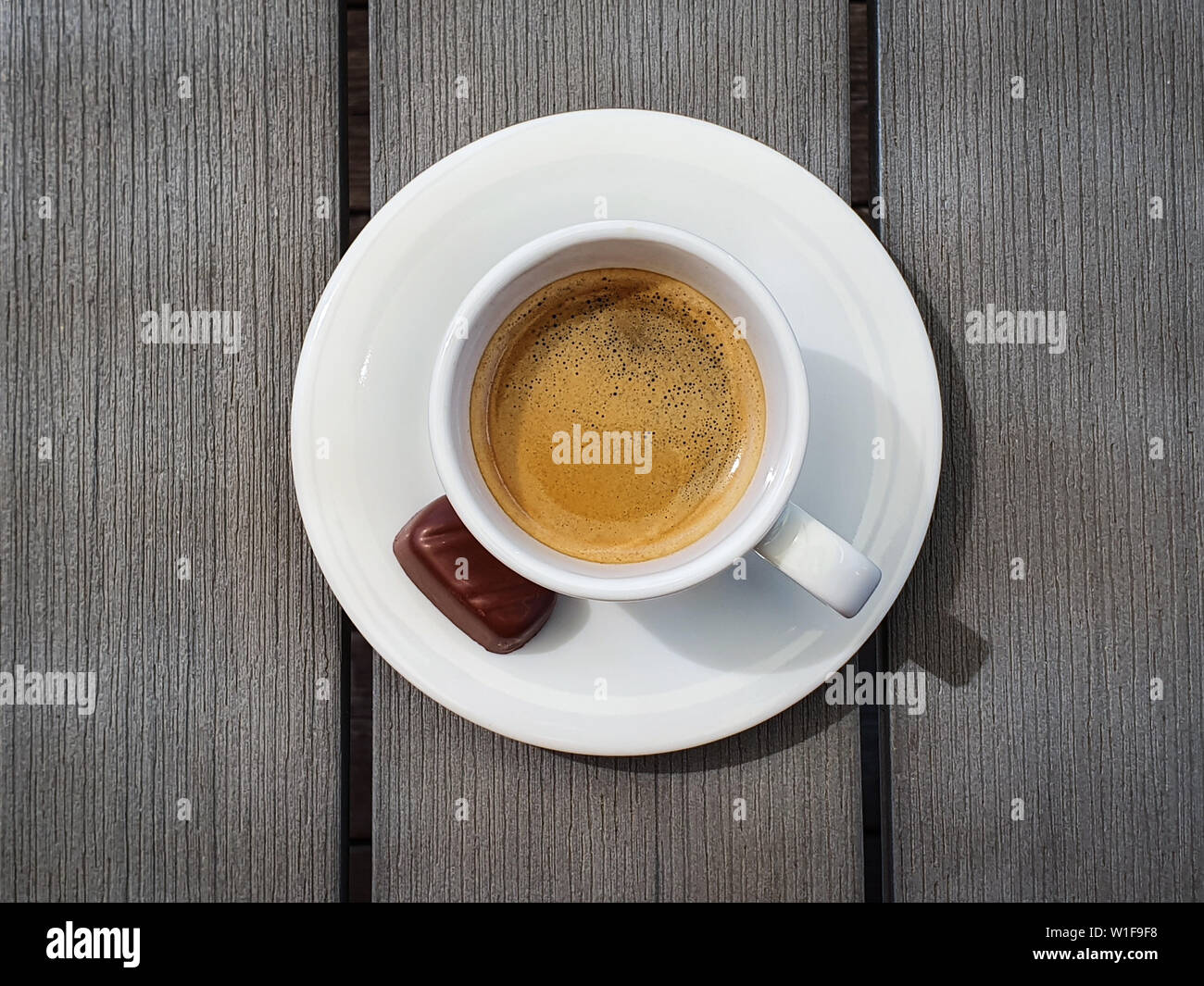 Tasse d'espresso avec petit chocolat praliné sur gris rustique table. Vue d'en haut Banque D'Images