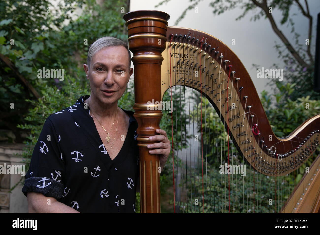 (190702) -- Athènes, 2 juillet 2019 (Xinhua) -- Le créateur de mode grec Vassilios Kostetsos pose avec une harpe dans le jardin de la Musée numismatique d'Athènes en Grèce, le 1 juillet 2019. Vassilios Kostetsos, l'un des grands couturiers de la Grèce au cours des trois dernières décennies, a présenté sa nouvelle collection "l'Aphrodite de Milo' Couture 2019-2020 ici lundi soir, en encourageant l'industrie de la mode de mettre l'accent sur la vraie figure féminine, juste la façon dont les anciens Grecs conçue de la beauté. Pour aller avec le grec 'Fashion designer présente collection inspirée par l'Aphrodite de Milo" (Xinhua/Partsali Lefteris Banque D'Images