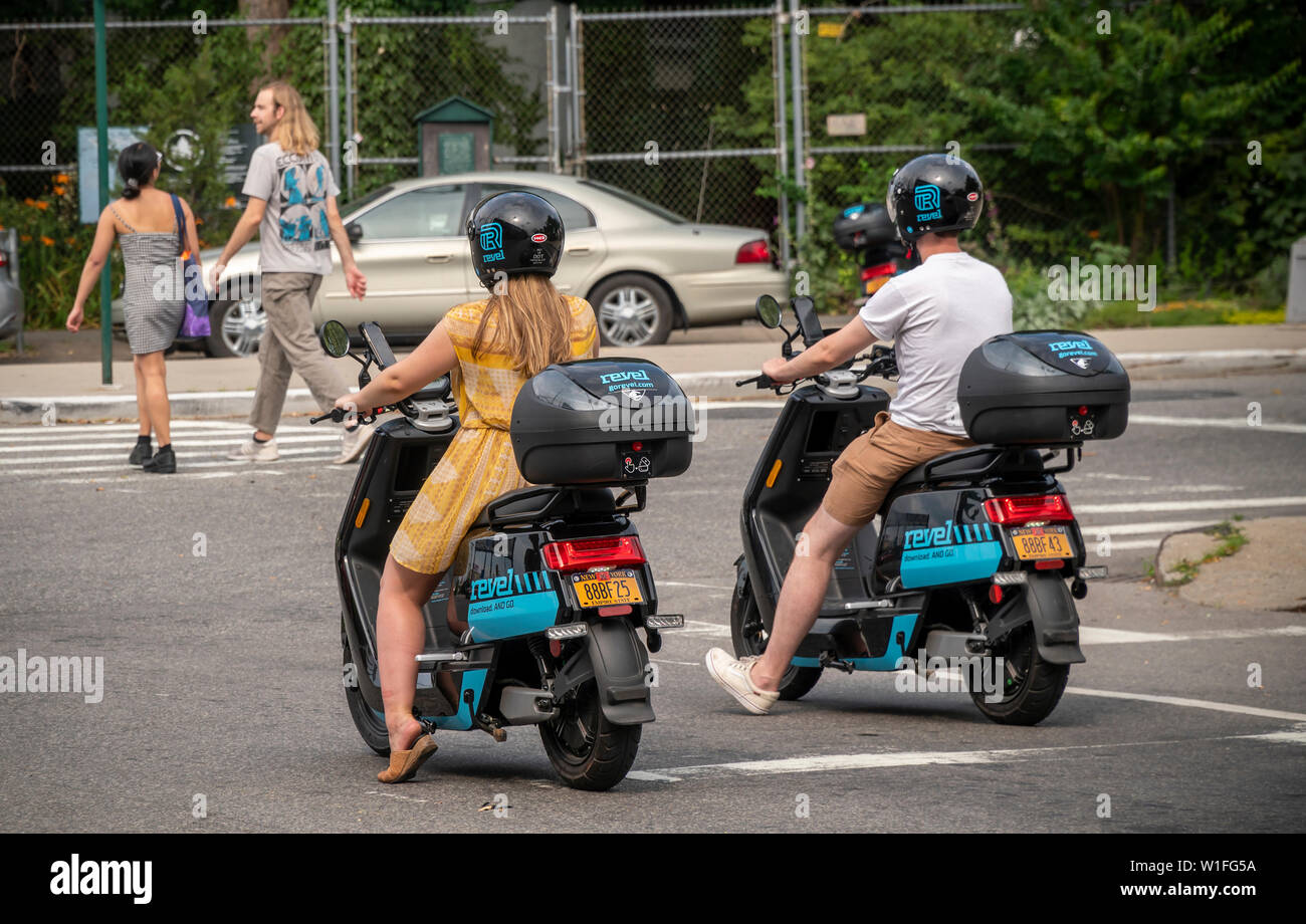 Les cavaliers sur un cyclomoteur électrique à partir de l'entreprise partage de cyclomoteurs Revel dans le quartier Red Hook de Brooklyn à New York le samedi, Juin 29, 2019. Revel Transit a récemment annoncé une expansion de leur flotte d'un modeste 68 à 1000 cyclomoteurs étendre plus loin dans Brooklyn et Queens. (© Richard B. Levine) Banque D'Images