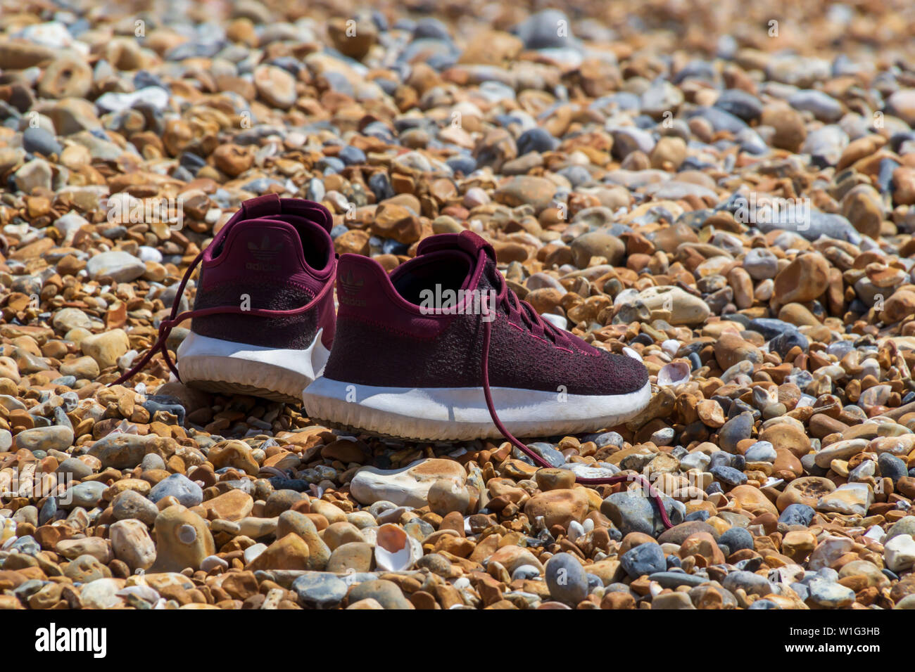 La paire de chaussures de course sont en attente de leur maître au bord de la mer alors qu'il participe à une sorte d'aventures. Banque D'Images