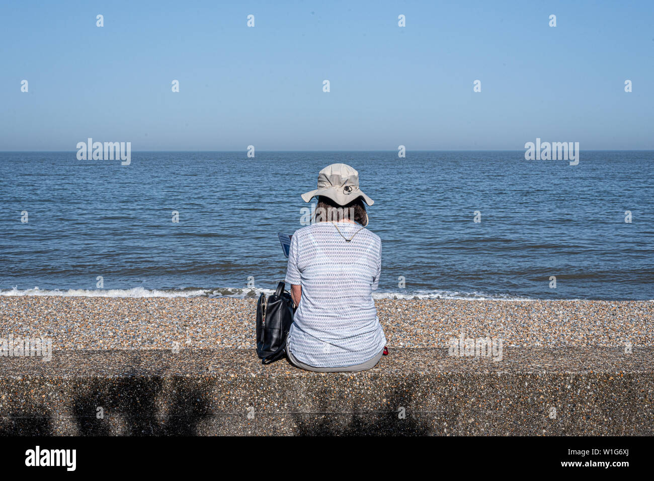 Checking mobile sur le front de mer à Aldeburgh, Suffolk, UK Banque D'Images