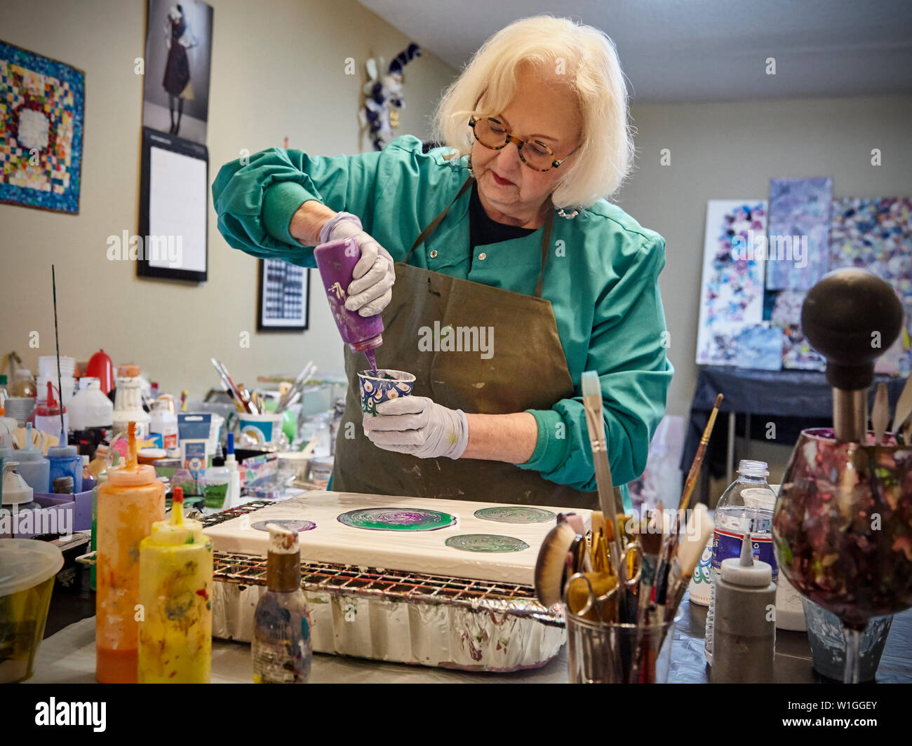 Dame à la retraite crée de l'art dans un home studio Banque D'Images