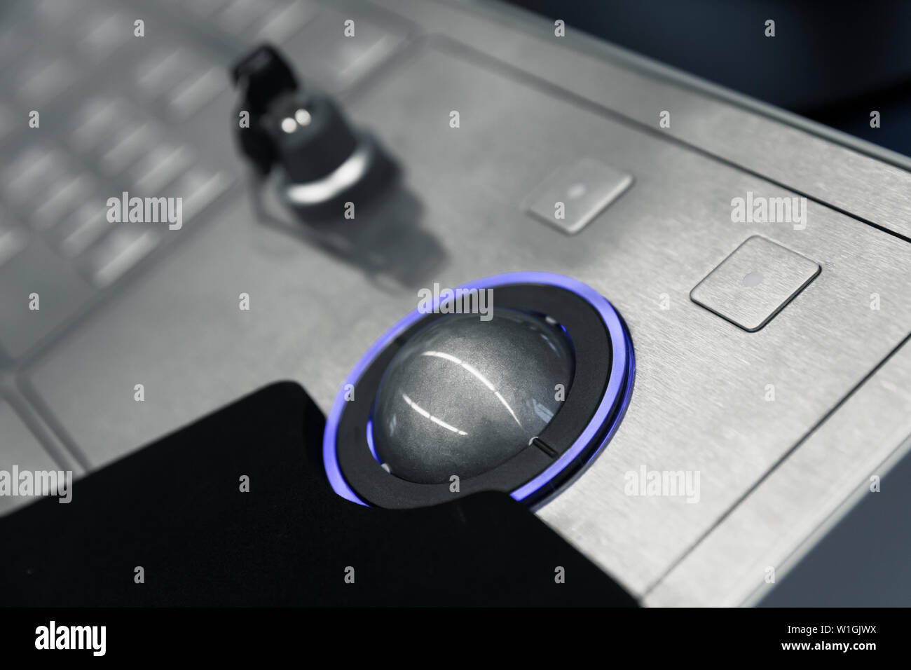 Panneau de contrôle industriel fait de métal gris bleu avec trackball et touche de verrouillage de sécurité, la photo en gros plan avec soft focus sélectif Banque D'Images