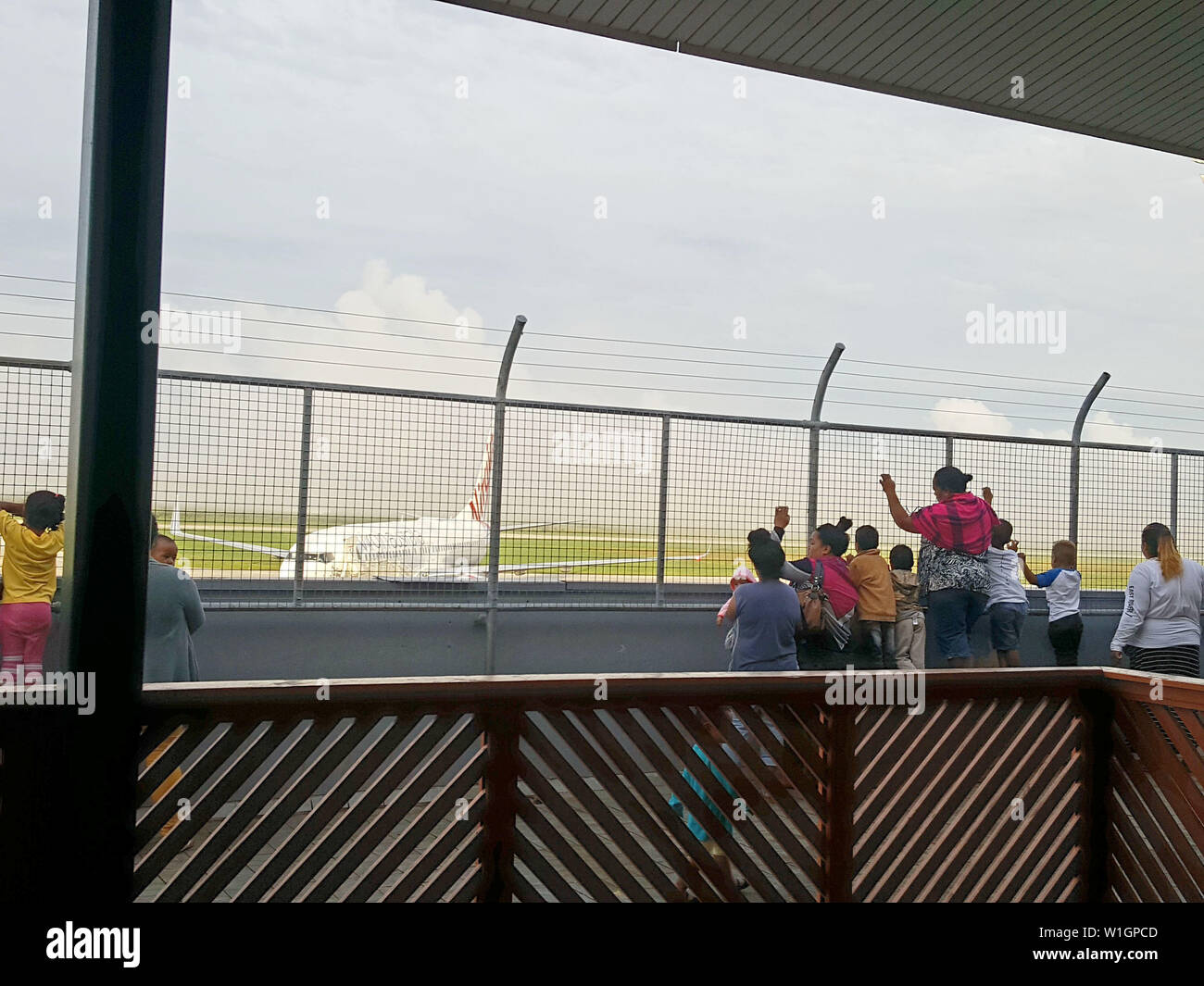 Les gens qui regardent un avion décoller à l'aéroport de Ha'apai, Tonga Banque D'Images