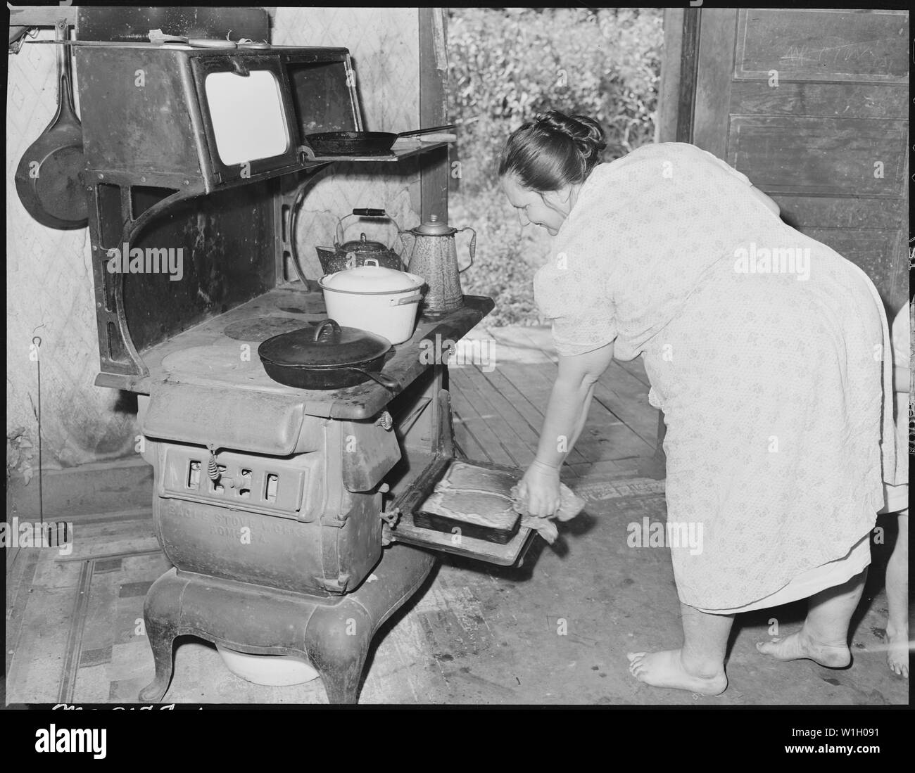 Mme Gillie Treadway, épouse d'un mineur, en prenant du pain frais du four. Le Treadways ont vécu dans ce camp pendant quatre ans et à la chambre pour trois ans. La chambre était propre, malgré son manque d'entretien peu recommandables ; elle a dit, il semble que je juste n'ai pas le coeur à faire. Fox Ridge Mining Company, Inc., Hanby Mine, Arjay, Bell County (Kentucky). Banque D'Images