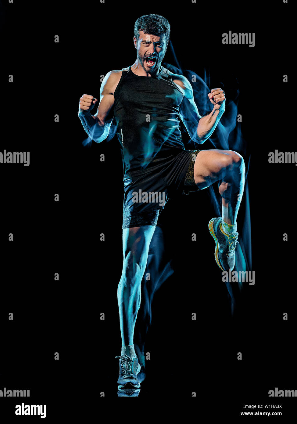 Un homme de race blanche player exercice fitness cardio-boxing combat corps exercice studio shot isolé sur fond noir avec le light painting effet flou Banque D'Images