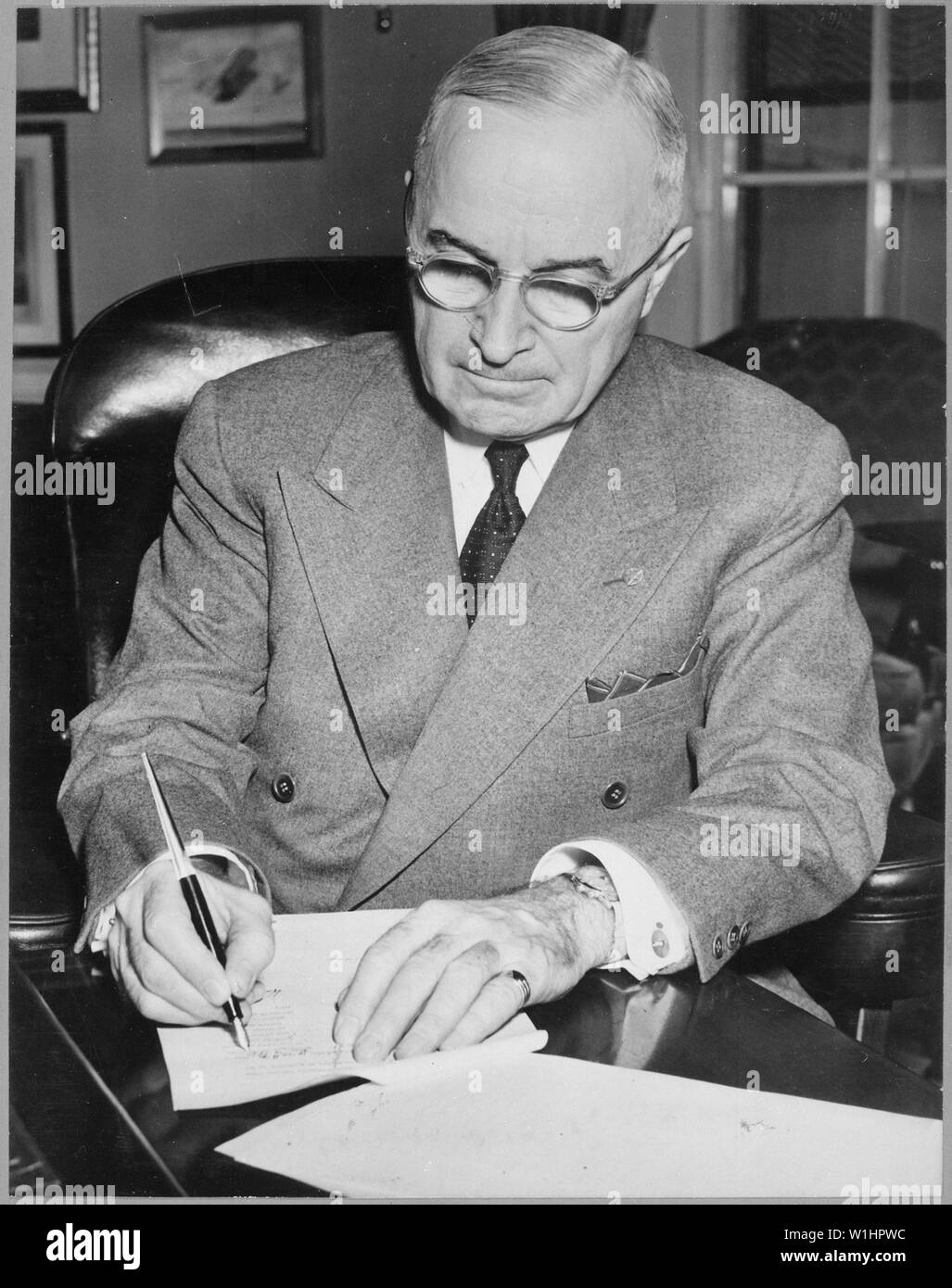 Le président Harry S. Truman est illustré à son bureau à la Maison Blanche  la signature d'une proclamation déclarant une urgence nationale. Acme. ;  notes générales : utilisation de la guerre et