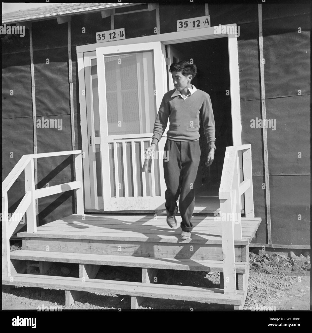 Rohwer, Centre de réinstallation, Arkansas. McGehee Un diplôme d'assistant de bureau laisse le principal's . . . ; Portée et contenu : la légende complète pour cette photographie se lit comme suit : Rohwer, Centre de réinstallation, Arkansas. McGehee Un diplôme d'assistant de bureau quitte le bureau du principal faire sonner la cloche de changement de classe temporaire. ( Une vache bell). Banque D'Images
