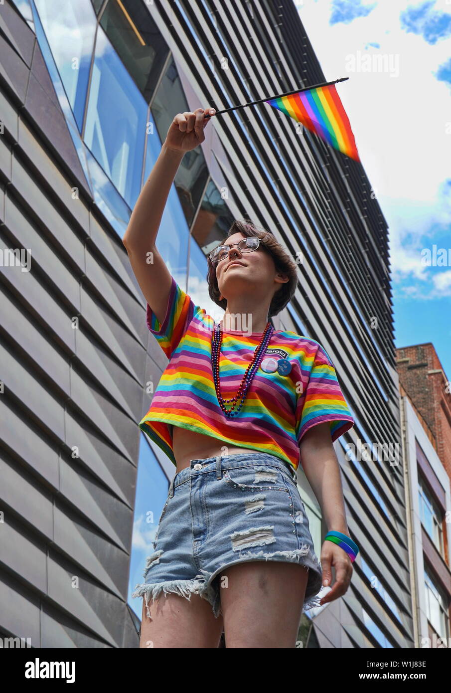 New York City, NY / USA - 20 juin 2019 : Young caucasian personne vagues du drapeau arc-en-ciel de la fierté à 2019 Banque D'Images