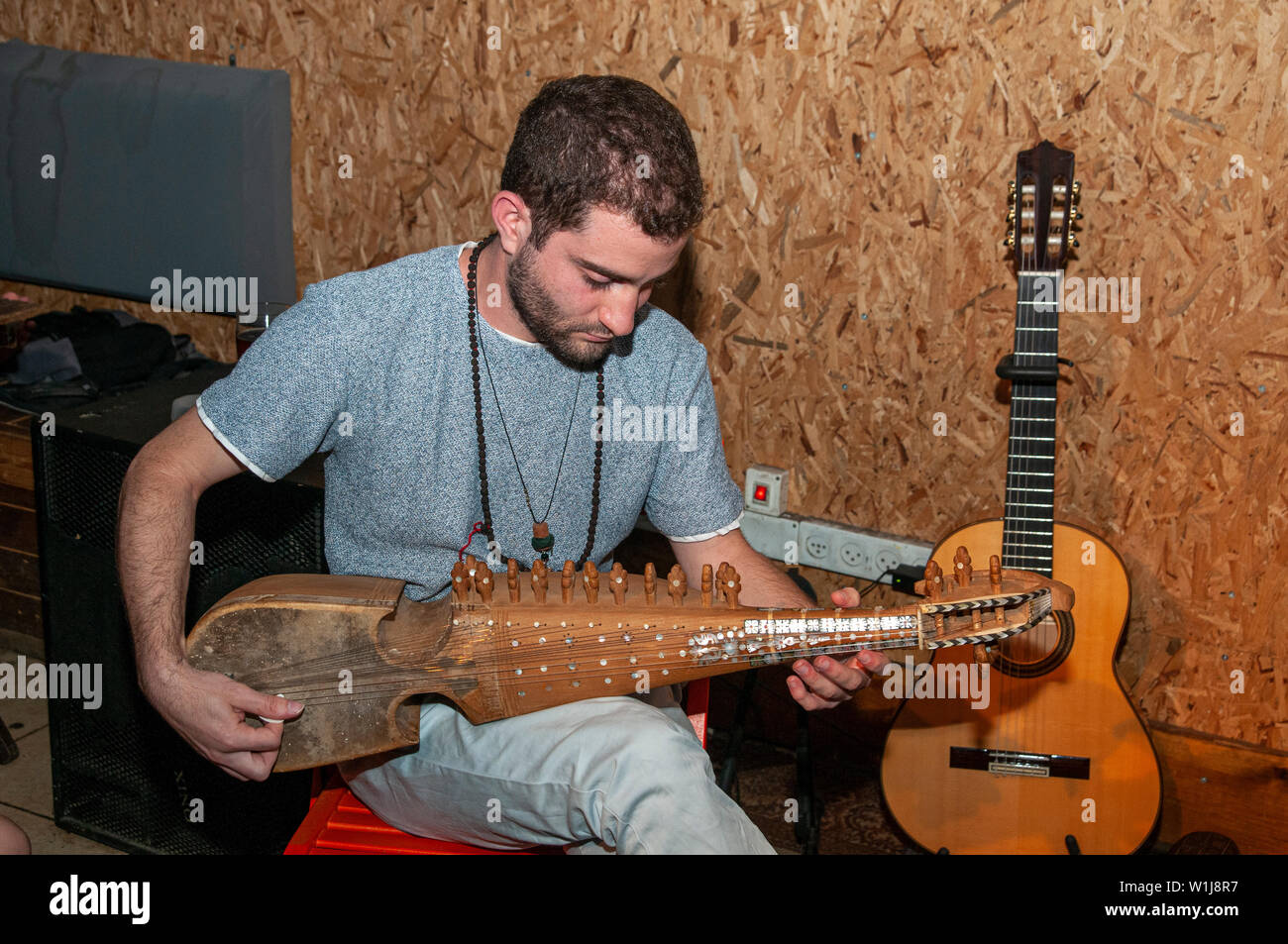 Young Caucasian musicien joue d'un instrument à cordes Rebab Afghan Banque D'Images