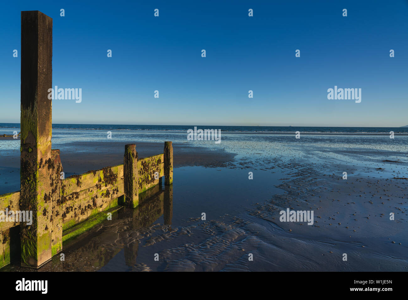 Des brise-lames de l'oeil dans une plage avec une marée basse prises sur la journée la plus longue de l'année Banque D'Images