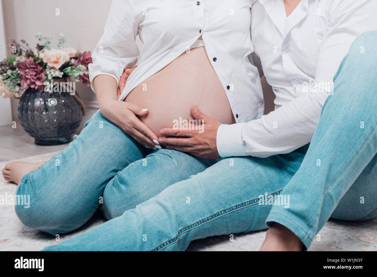 Femme enceinte et son mari sont maintenant les mains sur le ventre. Rognées. Banque D'Images
